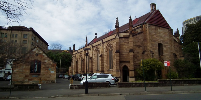 Historic Garrison Church in Sydney with cars parked outside and a clear road in the foreground