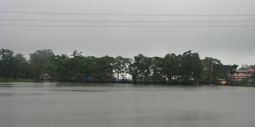 Lake with a scenic landscape, calm waters, and lush greenery similar to lakes in Noida