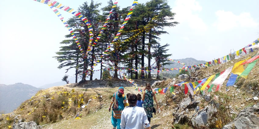 People walking on the George Everest trail with a sandy mountain peak