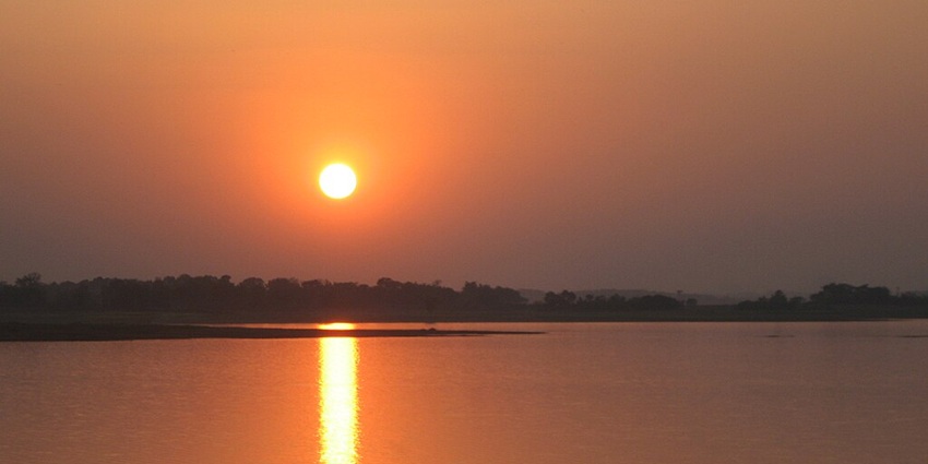 An image of Getalsud Dam Lake at sunset, surrounded by vast waters and surrounded by hills