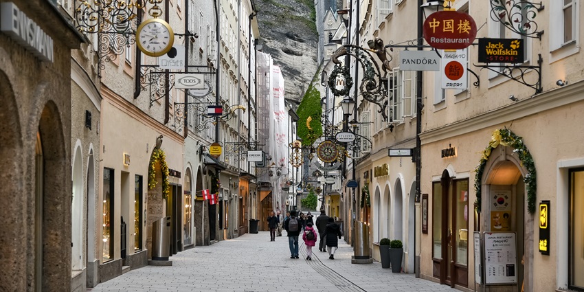 A charming shopping street in Salzburg with old-style signs and cobblestone paths