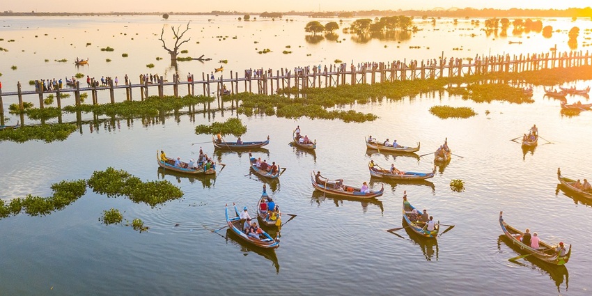 Wooden boundary over a tranquil lake with people, one of the lakes in Kangra, India.