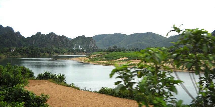 An image of the Gianh River in Vietnam, with calm waters flowing through a lush green landscape