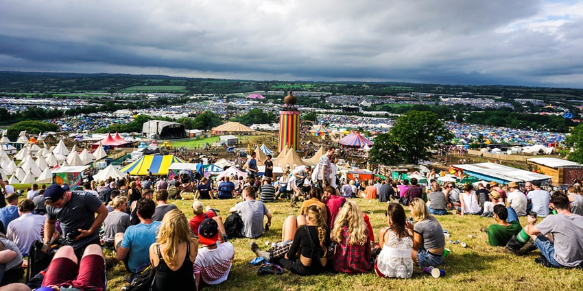 A view of visitors sitting and enjoying the music at a top music festival in the world.