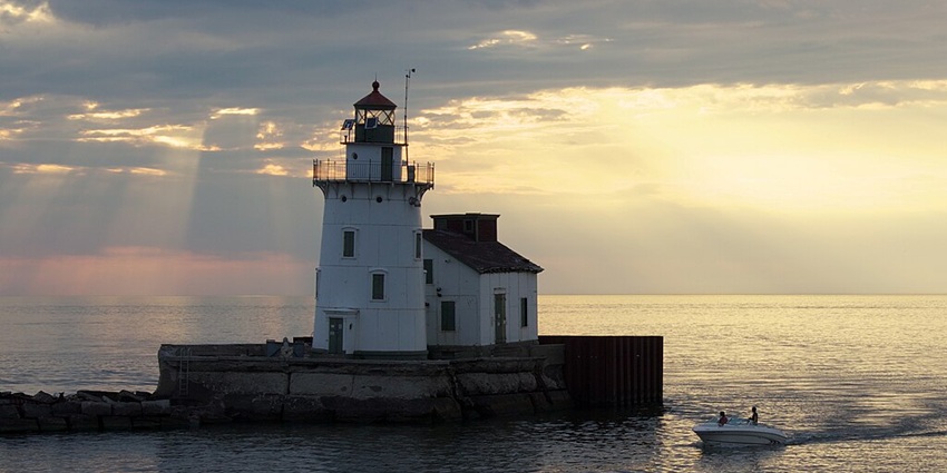 An image of two people on a speedboat near a lighthouse in Lake Erie, Pennsylvania, USA.