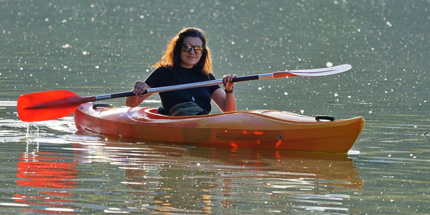 An image of a woman kayaking on the Kampot River, a famous thing to do in Kampot.