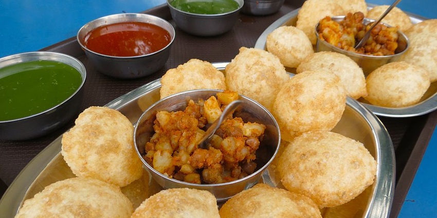Plate of crisp gol gappe filled with tangy spiced water and chutney, a North Indian street snack