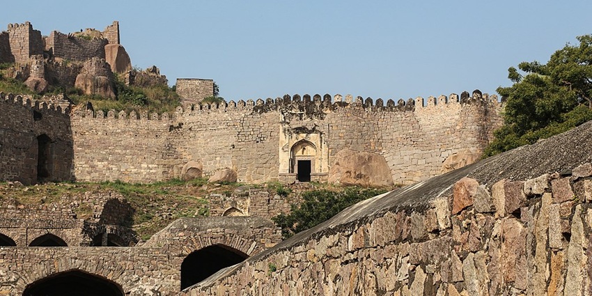 View inside the halls of Golconda fort, with lush trees against the walls