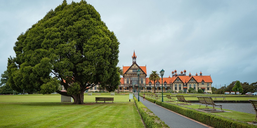 A view of Rotorua's Government Gardens with flowers, historic buildings, and lawns.