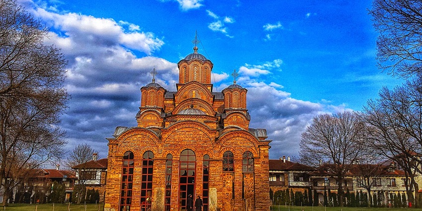 Exterior view of the historic Graçanica Monastery in Kosovo, showcasing its distinctive medieval Serbian Orthodox architecture.