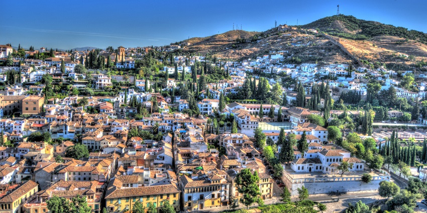 Alhambra palace in Granada with Moorish architecture set against the Sierra Nevada backdrop.