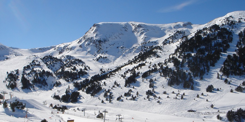 The ski resort of Grandvalira, with snow covering the entire landscape and pine trees jutting out