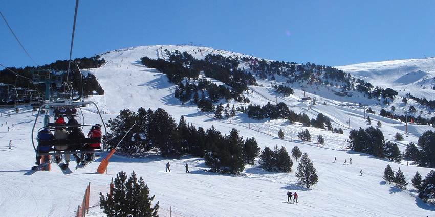 Skiers enjoying the slopes while chairlifts transport visitors up the snowy mountain