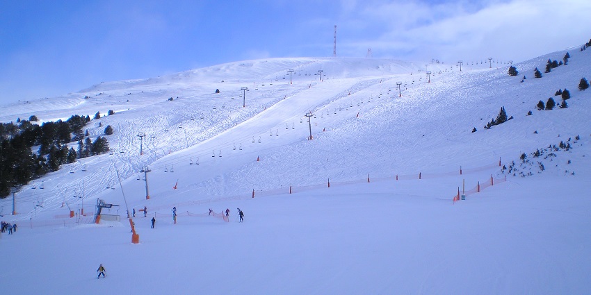 Skiers are sliding down snowy slopes while ski lifts are moving steadily uphill