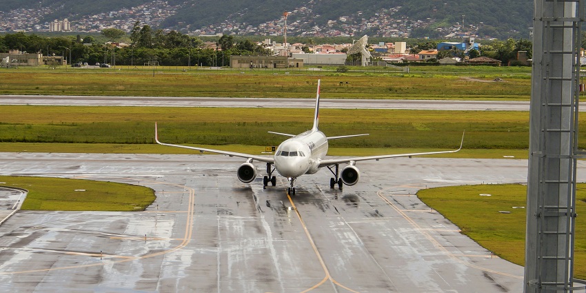Terminal of Gregorio Luperón International Airport, with parked vehicles and radio tower.