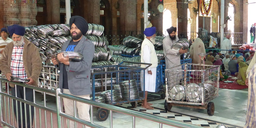 Langar (community kitchen) distributing or organising steel plates for serving free meals.
