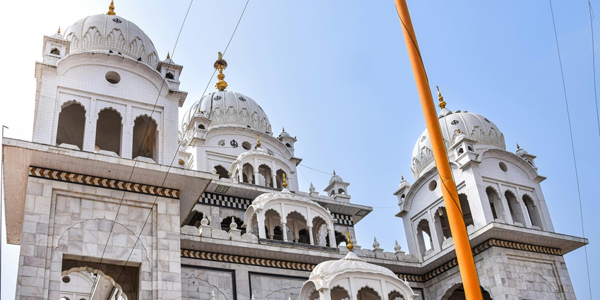Gurudwara Sri Kalgidhar Sahib with traditional sikh architecture and a tall flag hosted