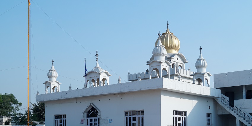 White structure and gold plated domes of Gurudwara in Sydney.