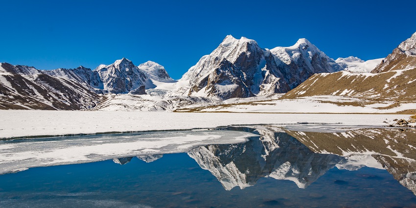 Gurudongmar Lake, with its bright blue waters, is surrounded by snow-capped mountains