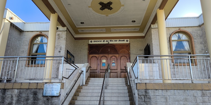 Gurudwara Sri Guru Singh Sabha with stairs leading to the entrance and a signage