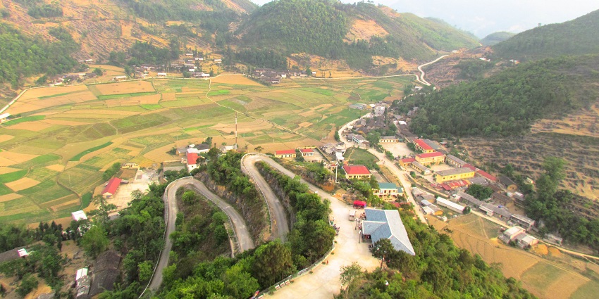 An image showing Ha Giang, Vietnam, with winding mountain roads and rugged limestone peaks.