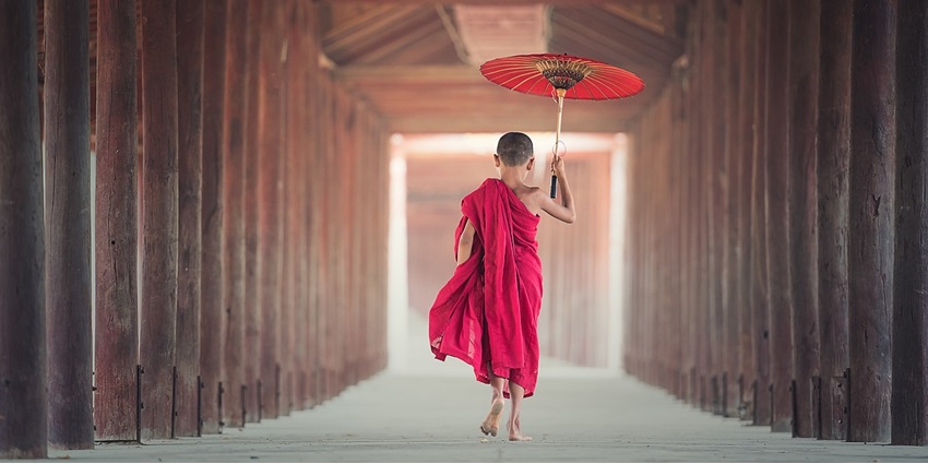 An image showing a monk child with an umbrella at a monastic school, similar to Haa Dratshang.