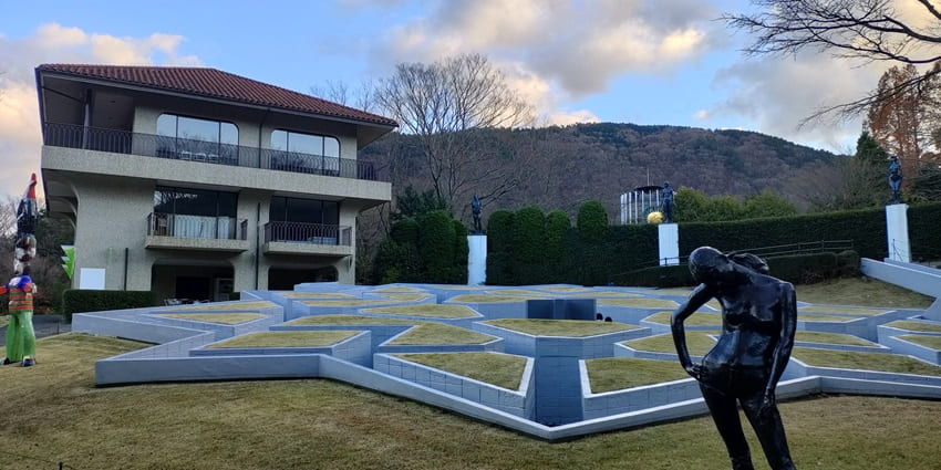 A black marble statue displayed amidst greenery in the premises of Hakone Open Air Museum.