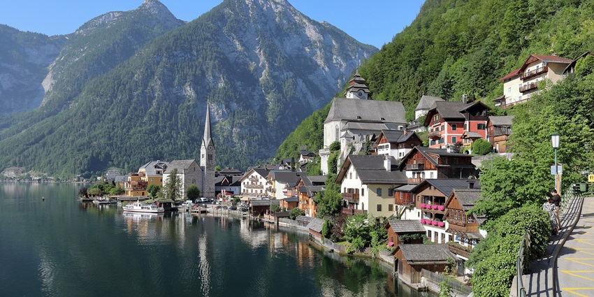A beautiful hill town in Austria with a lake flowing right next to it, creating a tranquil ambience
