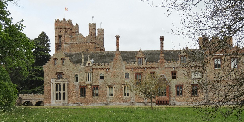 An image of a historic brick manor house with chimneys and a tower, resembling the Hampden Estate in Falmouth.