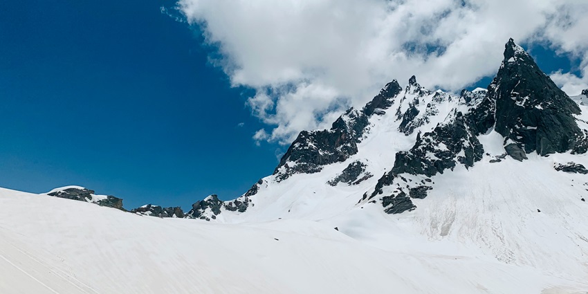 A trekker crossing the snowy meadows of Hampta Pass, one of the places for trekking.