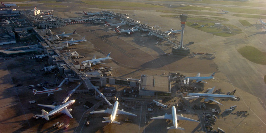An aerial view of Heathrow Airport shows planes parked near the terminal building.