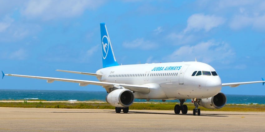 Blue and white commercial airplane parked at the runway of one of the airports in Djibouti.
