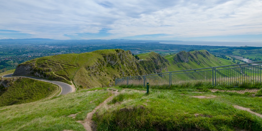 Image of green, grassy hills with rocky cliffs of Te Mata Peak, hiking here is one of the popular things to do in Napier.