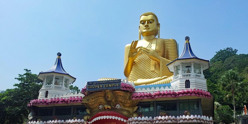 A historic mural and Buddha statues inside the Dambulla Cave Temple showcasing heritage.