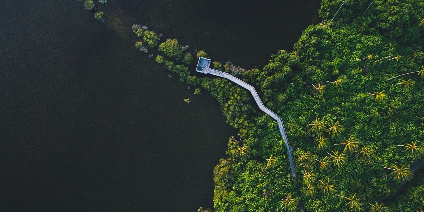 An aerial view of Addu City in Maldives surrounded by azure waters and lush vegetation.
