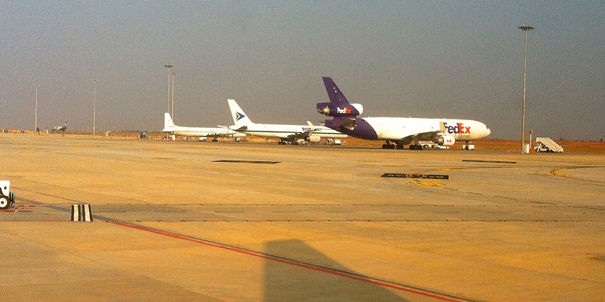 Runway of Pune International Airport with multiple airplanes parked and runway lights