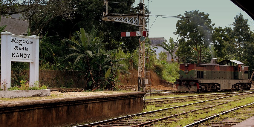 Kandy Railway Station with an old diesel train, semaphore signal, and lush greenery
