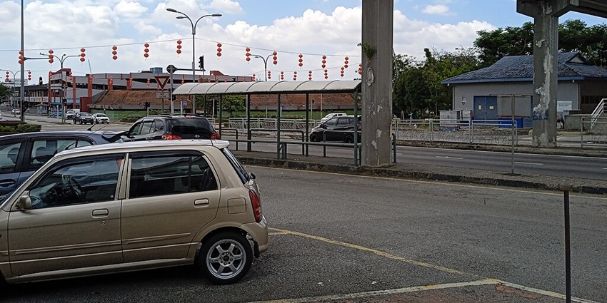 An image of festive street decorations with red lanterns, a signboard, parked cars