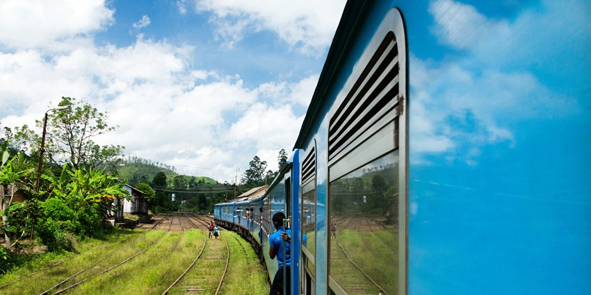 Jaffna Railway Station with a train arriving on the platform during the day with people.