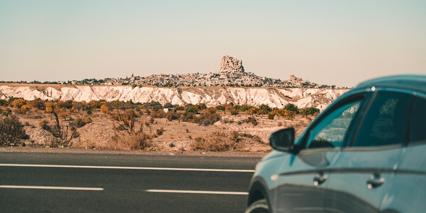 An image of a scenic road, flanked by Cappadocia’s distinctive rock formations and open skies.