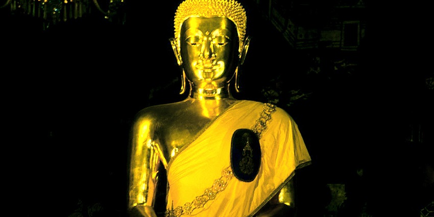 A picture of Bangkok Gold Buddha with visitors admiring its intricate golden details.