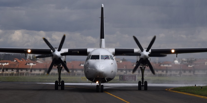 Fokker 50 aircraft at Nairobi airport, Kenya, parked on the runway under a clear sky