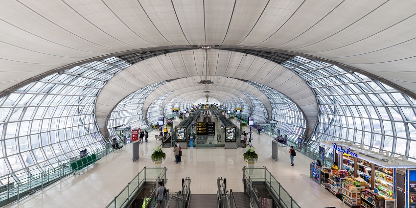 A check-in counter at Bangkok Suvarnabhumi Airport, showcasing a busy terminal scene.