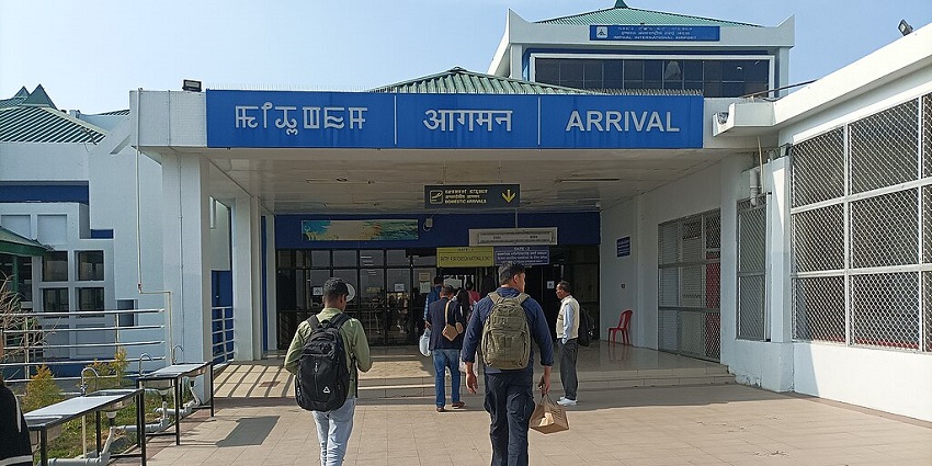 Imphal international airport with entrance and signboards in different languages.