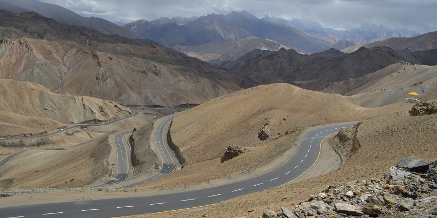 Jammu-Srinagar highway surrounded by sandy grounds and mountains under a cloudy sky