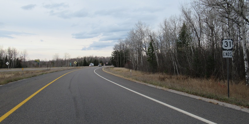 US-31 road with a sign board on the side of the road, distant moving vehicles and trees.
Viewers of this file can see comments and suggestions