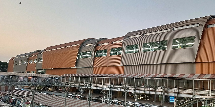 Pune Junction Railway Station in the evening with lights and bustling commuters.