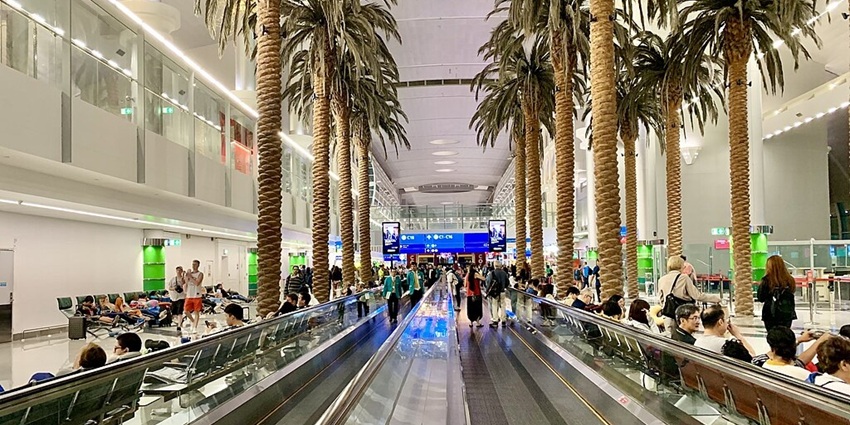 Interior of Dubai International Airport with travellers, modern architecture, and luxury amenities