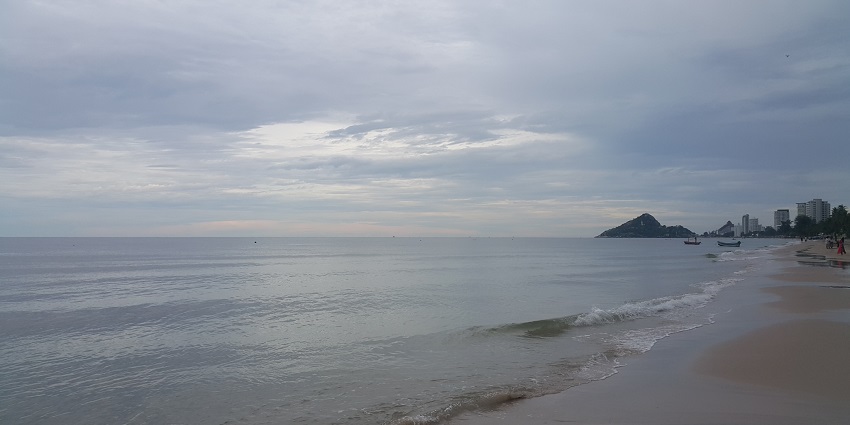 Shoreline of Hua Hin Beach in Thailand with sandy shore and clear waters.