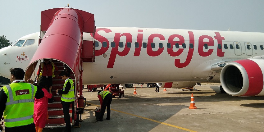 Passenger boarding flight at Kanpur Airport on a bright day.